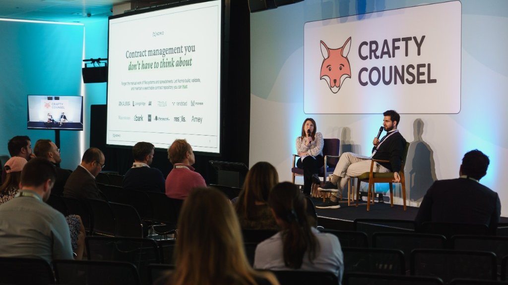 Penny Laver interviewed on stage at Crafty Counsel’s Legal Tech Buyers’ Club, with a Nomio slide on the screen behind her